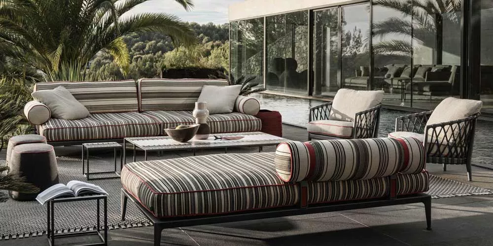 B&B Italia Ribes Outdoor Loungegruppe mit Loungesofa und Sesseln auf einer Terrasse neben einem Pool umgeben von Palmen und moderner Architektur