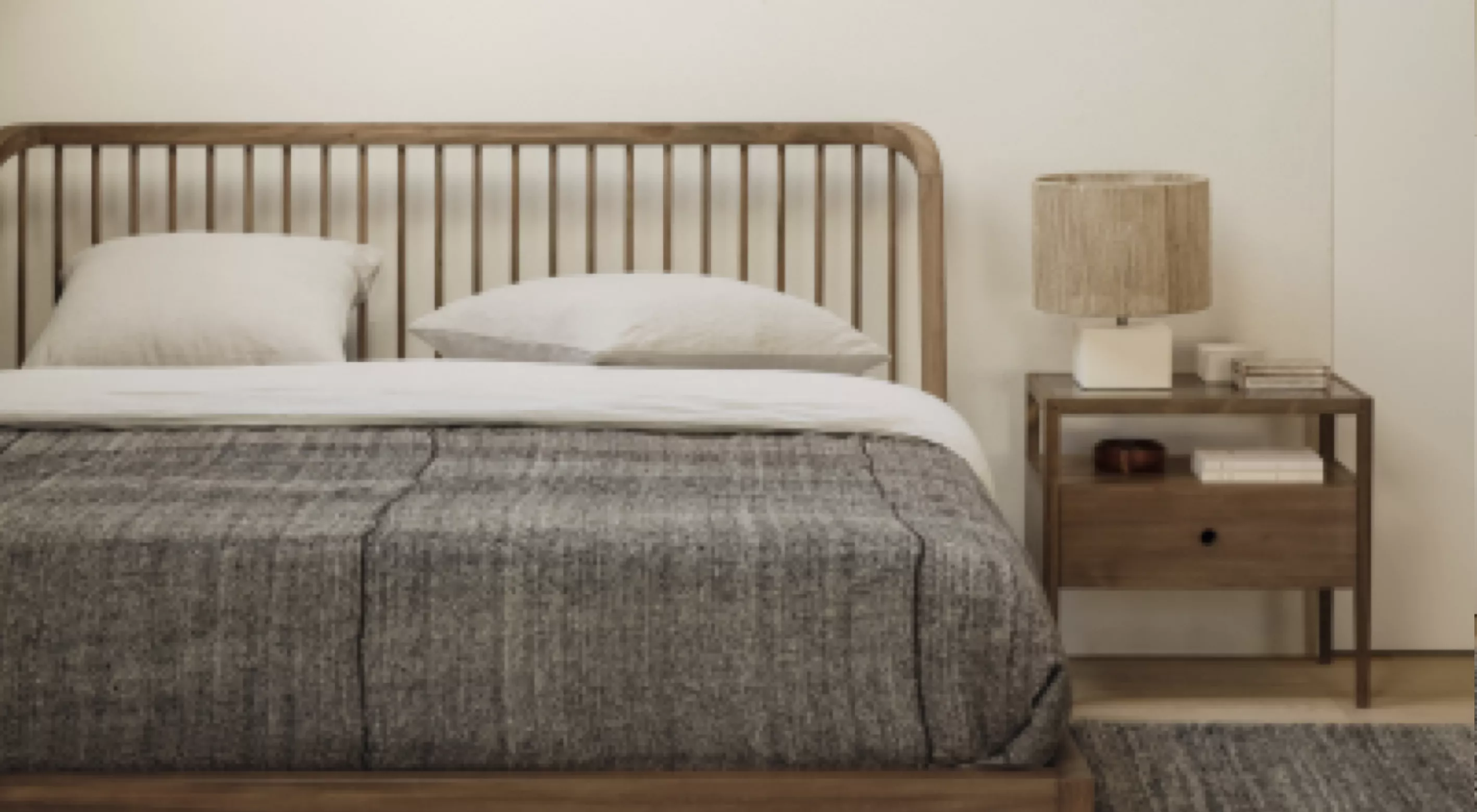 Holzbett mit grauer Bettdecke und Nachttisch mit Lampe in modernem Schlafzimmer auf hellem Holzboden.