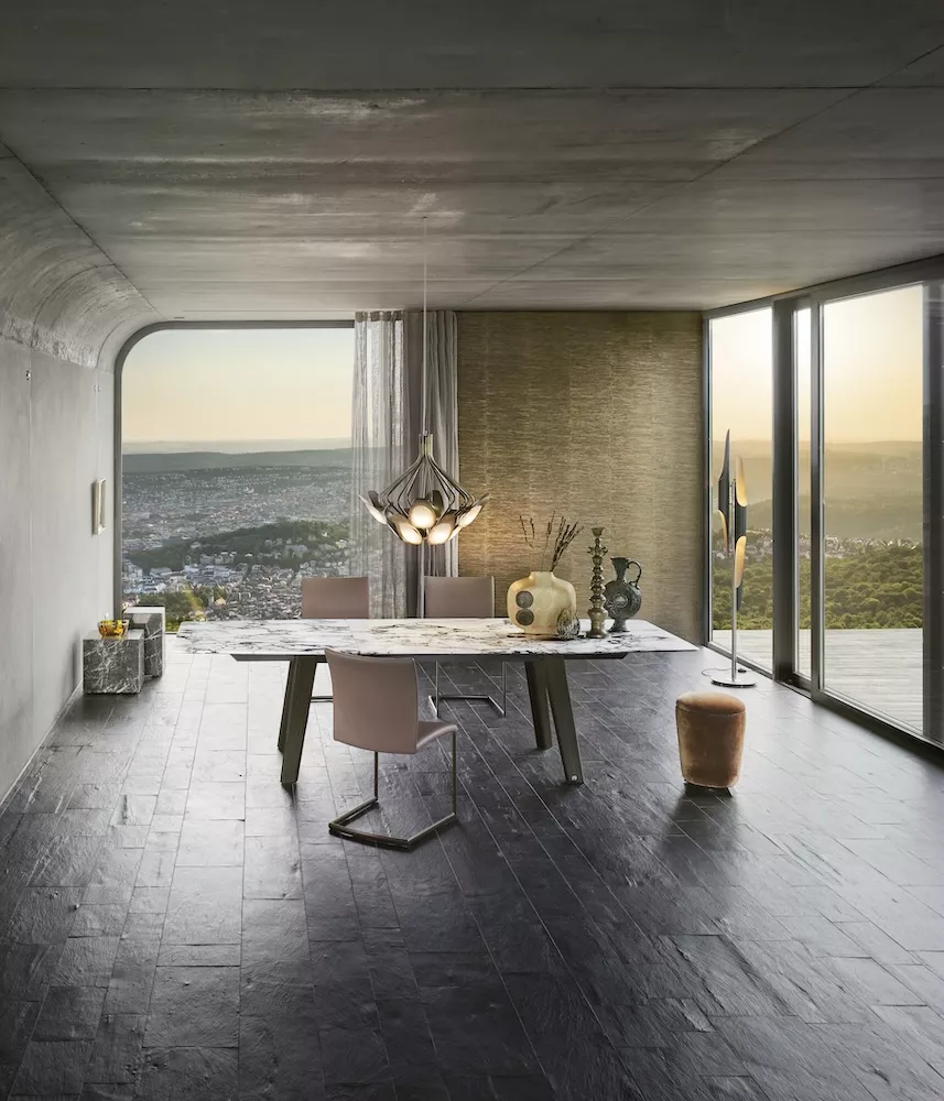 Esszimmer mit Fontana Tisch von Draenert und modernen Stühlen in einem stilvollen Raum mit Panoramablick auf die Stadt bei Sonnenuntergang