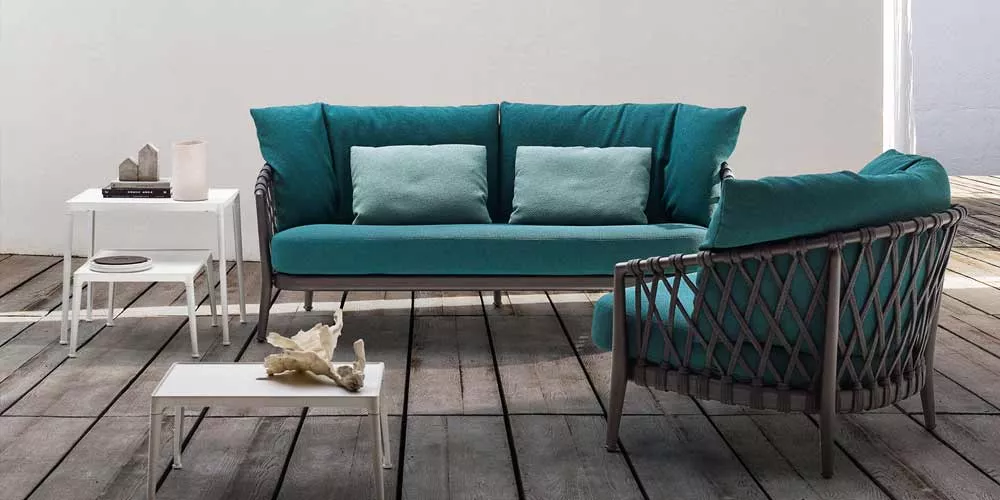 B&B Italia Erica Outdoor Loungegruppe mit Loungesofa und Sessel in einem modernen Außenbereich mit Holzboden und weißen Beistelltischen