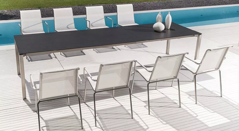 Fischer Möbel Modena Essgruppe in Weiß mit großem rechteckigem Tisch und acht Stühlen auf einer Terrasse am Pool, technische Ansicht.