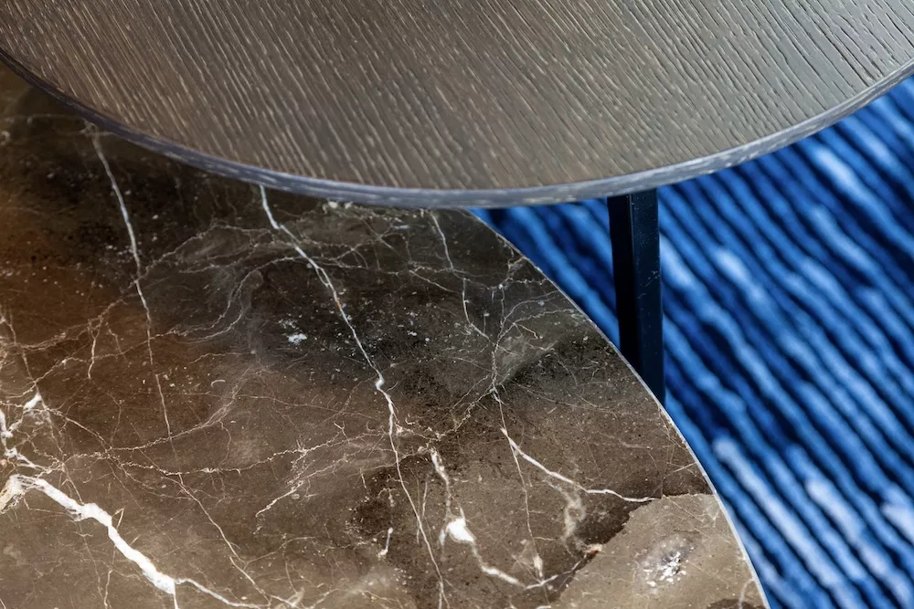 Draenert Tosca Beistelltische mit runden Platten aus Holz und Marmor auf blauem Teppich