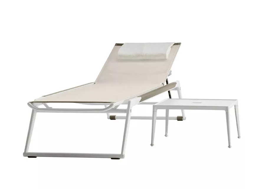 B&B Italia Mirto Outdoor Beistelltisch in Weiß neben einer Sonnenliege ohne Hintergrund