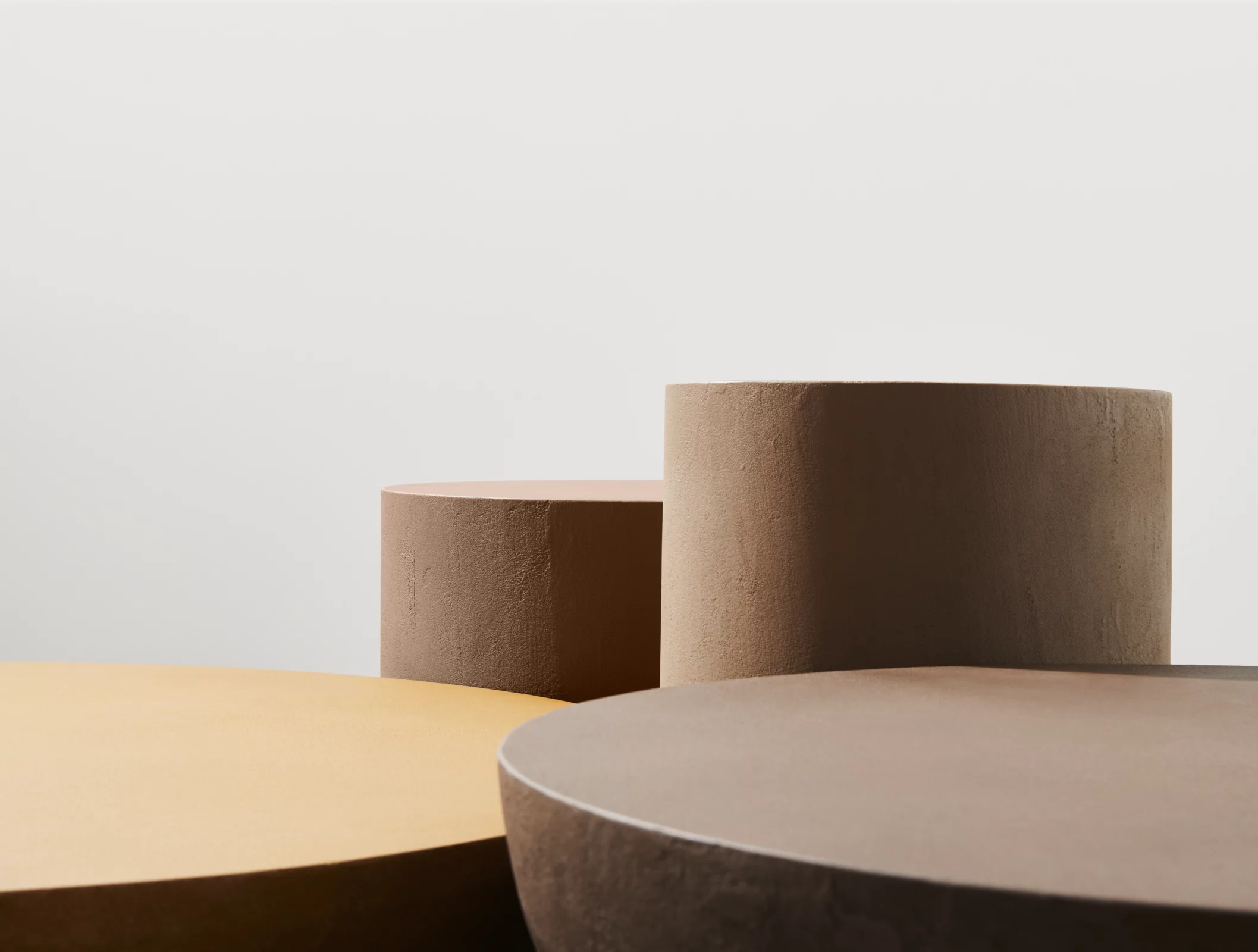 Gervasoni Kollektion zeigt runde Tische in verschiedenen Erdtönen vor einem neutralen Hintergrund