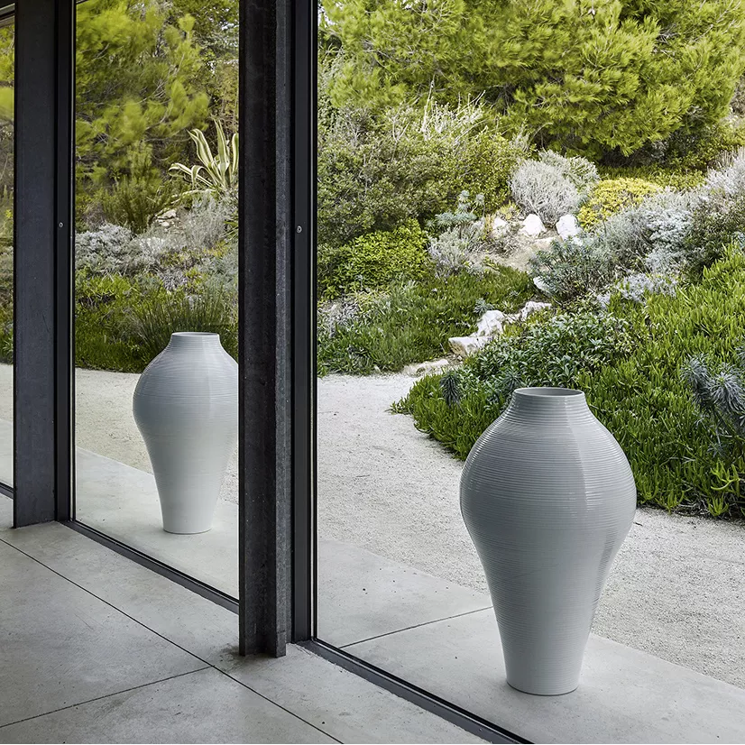 B&B Italia White Collection Vase steht vor einer Glaswand mit Blick auf einen grünen Garten im Hintergrund