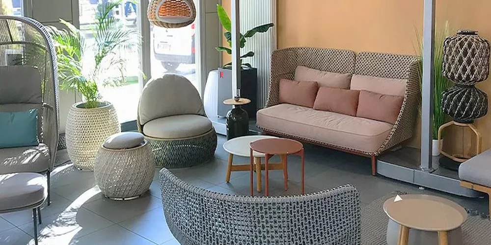 Gemütliche Lounge mit Villa Schmidt Möbeln in neutralen Tönen, umgeben von Pflanzen, in einem sonnendurchfluteten Raum.