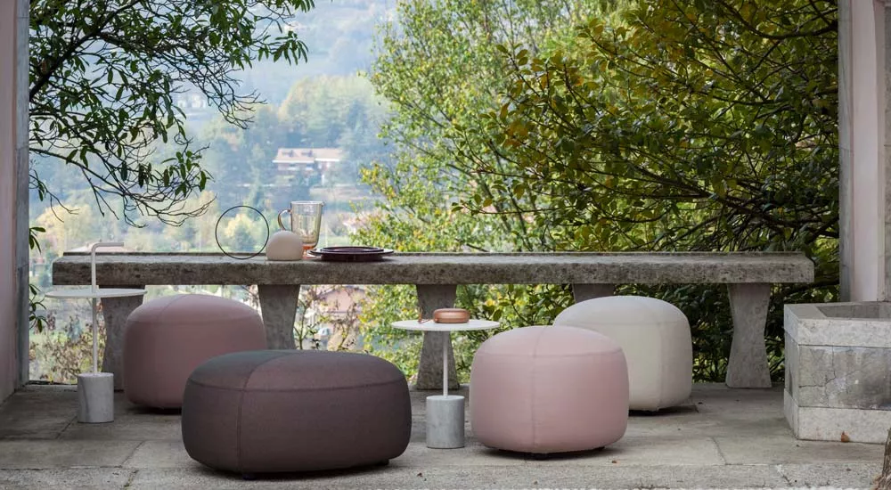 Lapalma KIPU Outdoor-Hocker in Rosa und Weiß auf einer Terrasse mit Blick auf eine grüne Landschaft.