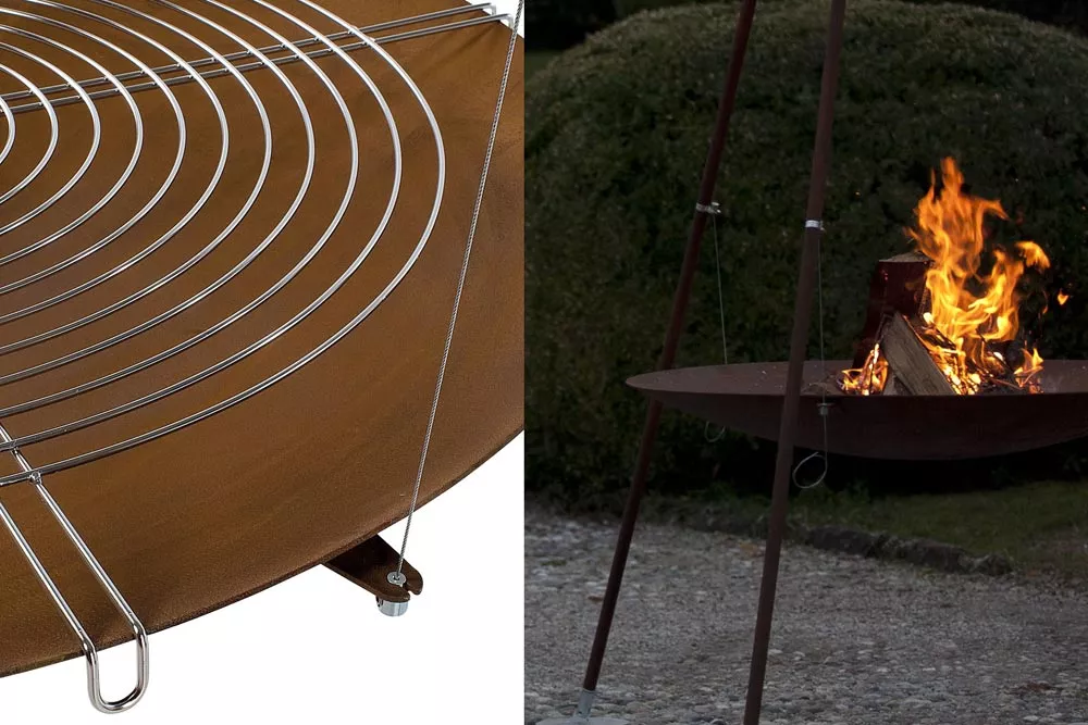 AK47 Tripee Feuerstelle aus oxidiertem Stahl 120 cm im Garten mit brennendem Feuer und Grillrost