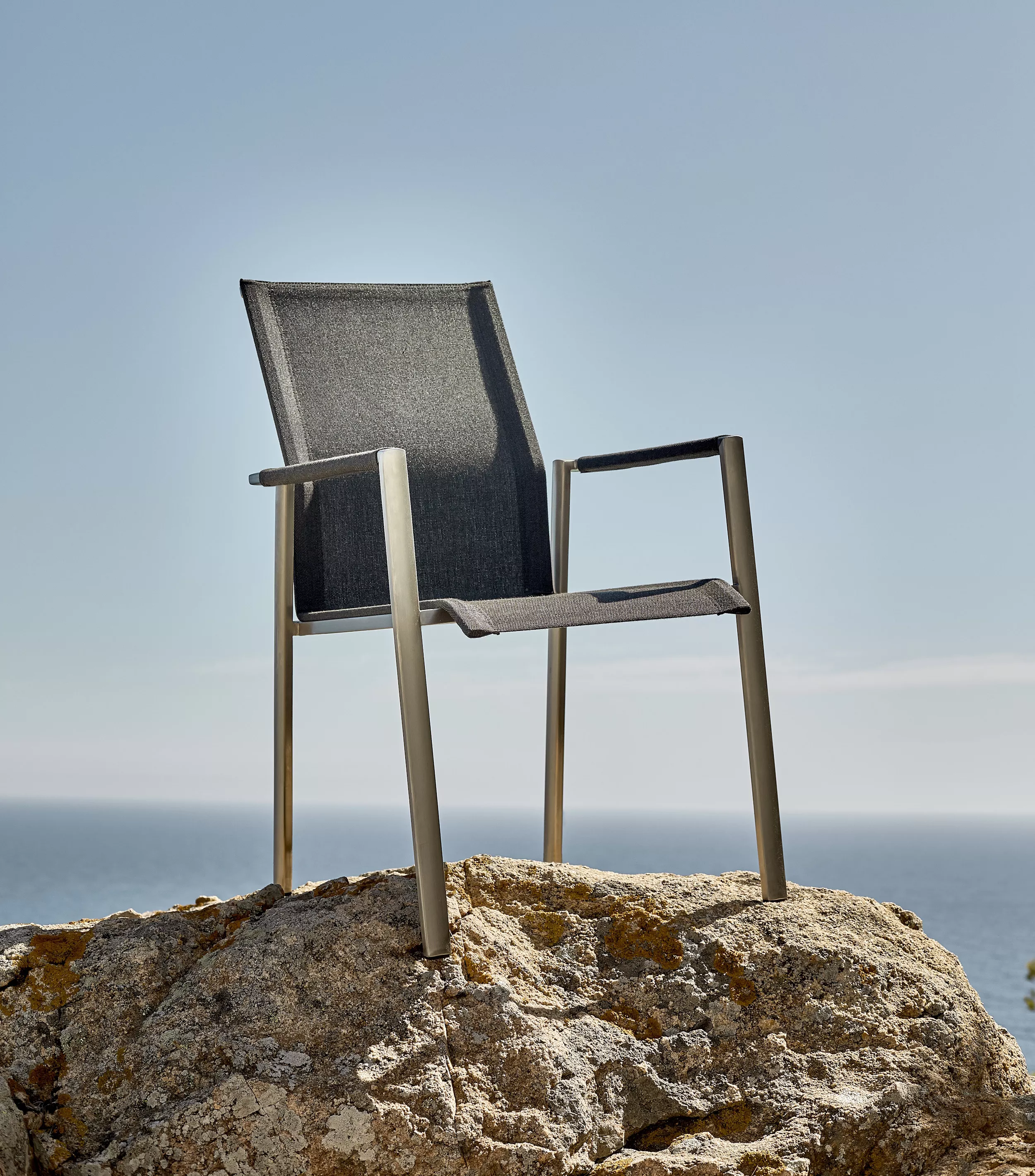 Solpuri Dance Stuhl steht auf einem Felsen mit Blick auf das Meer Mood Bild