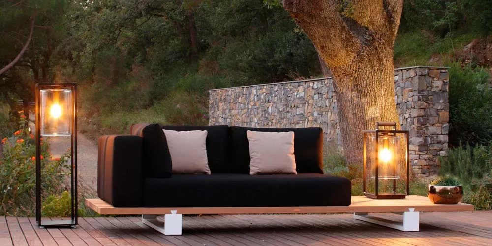 Royal Botania Dome Gartenleuchten in Schwarz, stimmungsvolle Beleuchtung auf Holzterrasse neben Sofa und Baum im Freien.