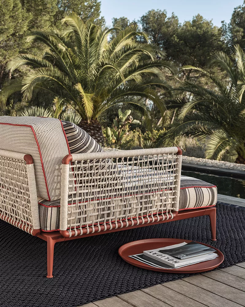B&B Italia Ribes Outdoor Lounge in einem Garten mit Palmen im Hintergrund und einem Tisch mit Zeitschriften auf einem Teppich