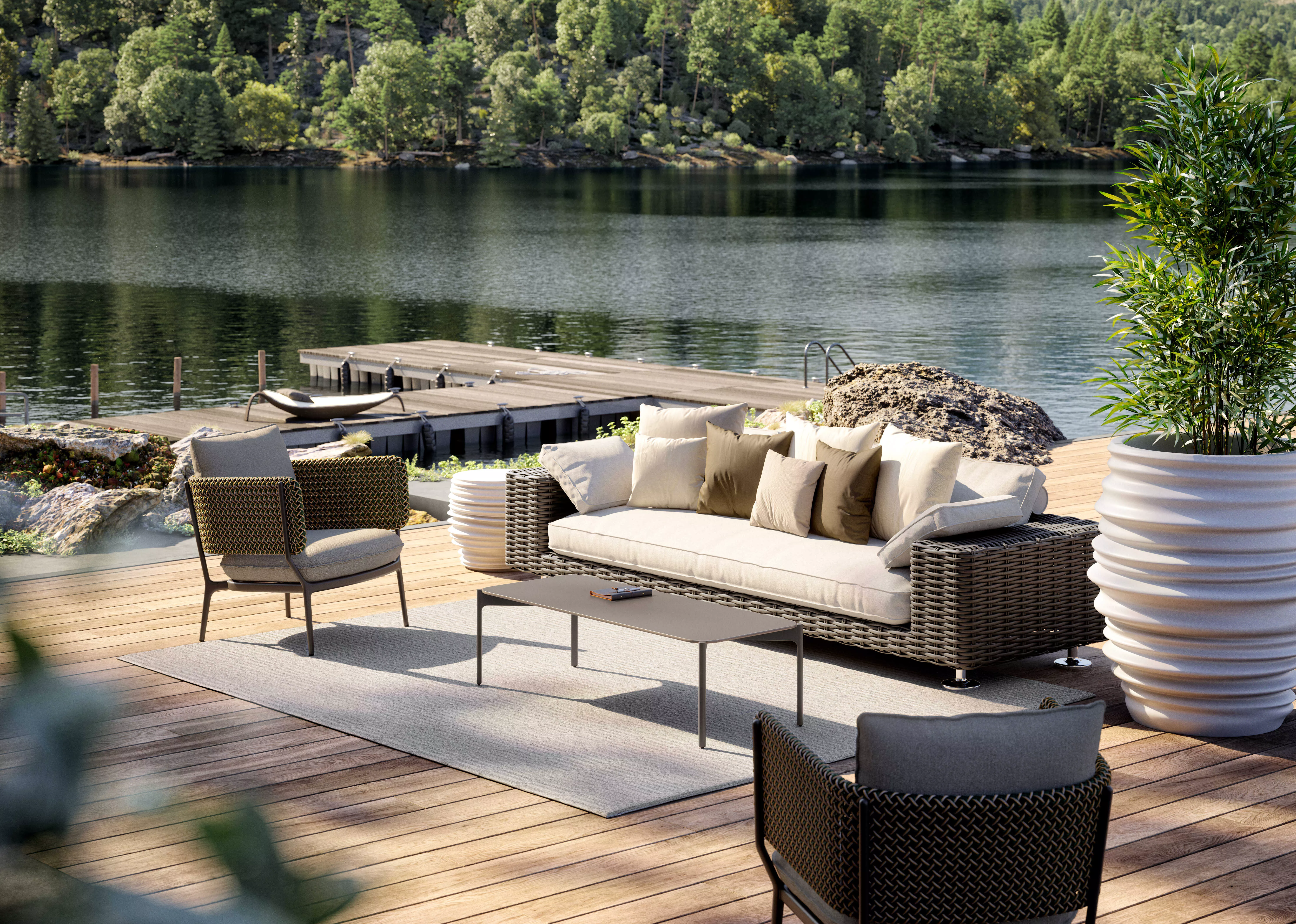 Dedon Secret Lakeside Paros Bellmonde Izon Leaf Babylon Gartenmöbel auf einer Terrasse mit Blick auf einen See und umgeben von Bäumen