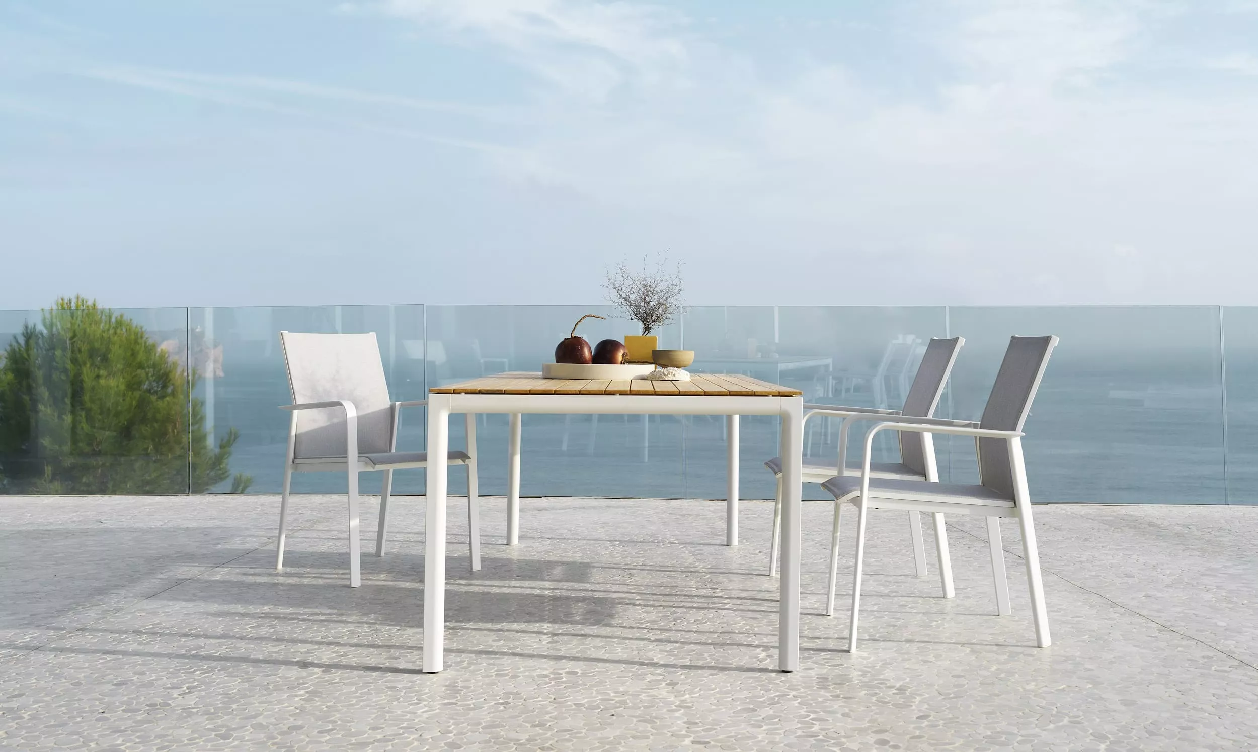 Solpuri Breeze Tisch und Stühle auf einer Terrasse mit Meerblick und Dekoration auf dem Tisch Mood Bild