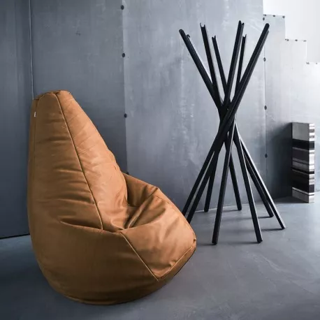 Brauner Sciangai Kleiderständer von Zanotta vor grauer Betonwand, modernes Design, neben einem braunen Sitzsack.