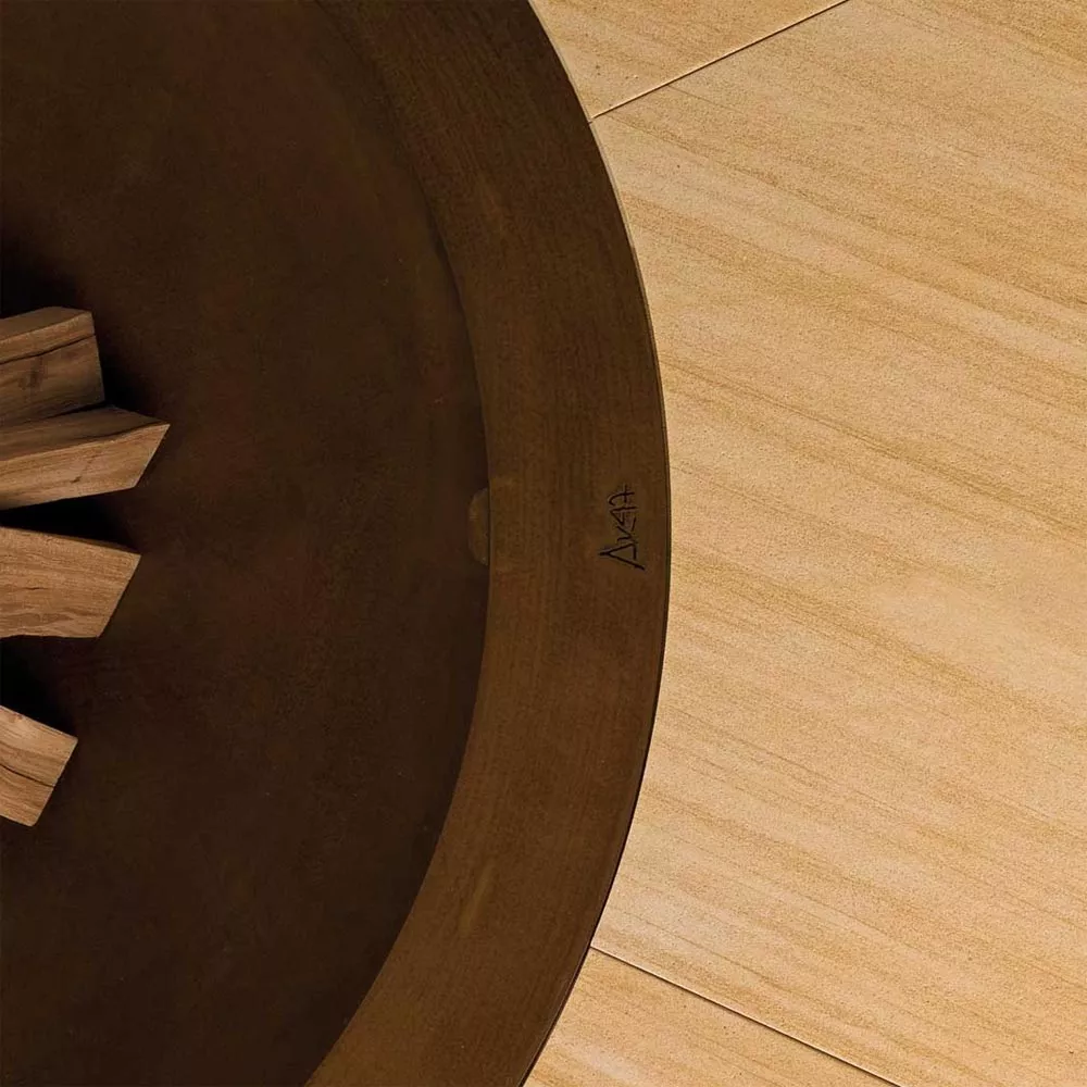 AK47 Ercole Feuerstelle aus Marmor Sandy Stahl in XSmall 120 cm auf einer Holzoberfläche ohne Hintergrund