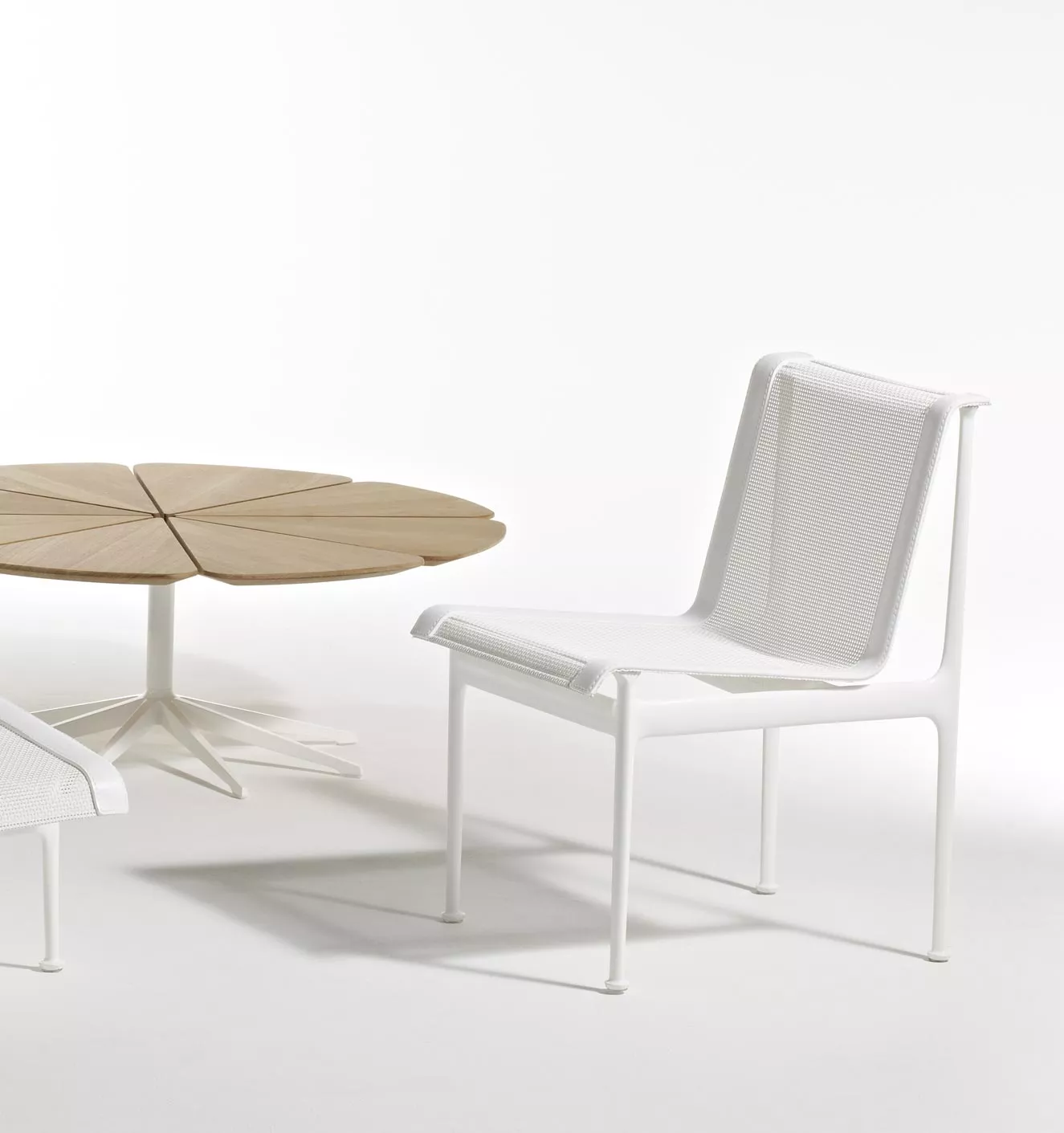 Knoll Studio 1966 Collection Essstuhl in Weiß neben einem runden Holztisch mit blütenförmiger Tischplatte ohne Hintergrund