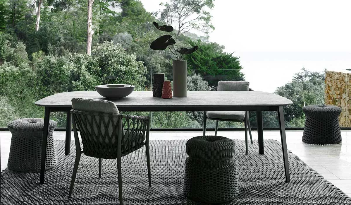 Essgruppe BeB Italia Ginepro in einem modernen Esszimmer mit Blick auf einen grünen Garten und stilvollen Dekorationen auf dem Tisch