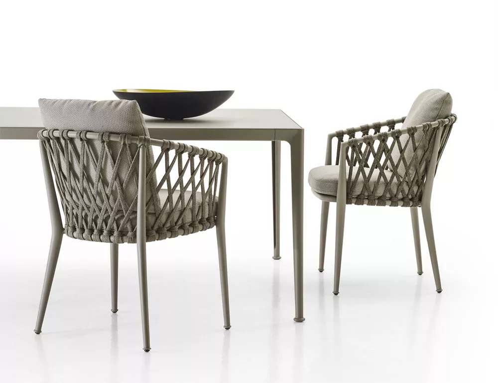 B&B Italia Erica Armlehnstuhl in einem modernen Esszimmer mit einem Tisch und einer Schale auf dem Tisch