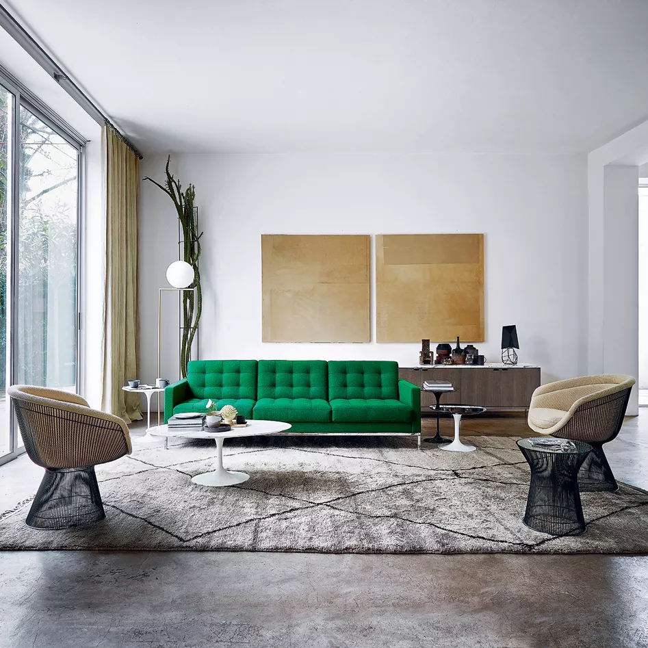 Grünes Florence Knoll Relax Sofa in modernem Wohnzimmer mit großen Fenstern und minimalistischer Dekoration, Perspektive von vorne.