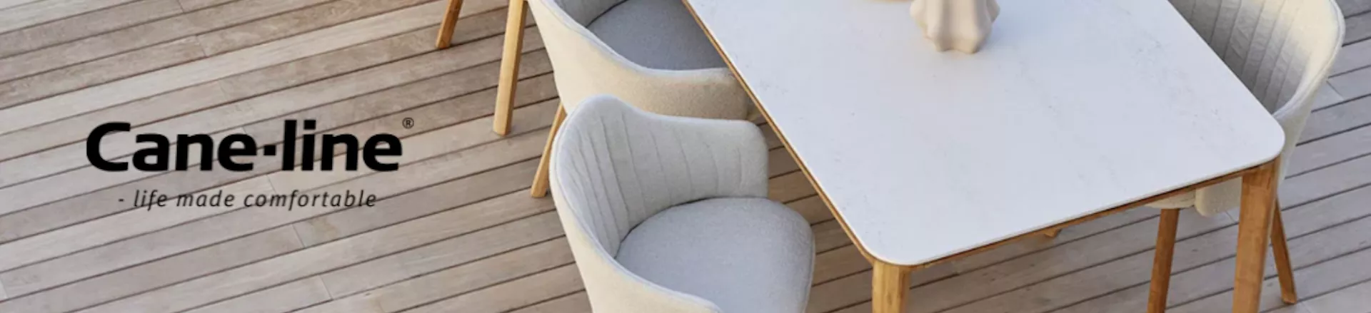 Cane-line Banner mit beigem Tisch und Stühlen auf Holzterrasse, aus Vogelperspektive fotografiert.