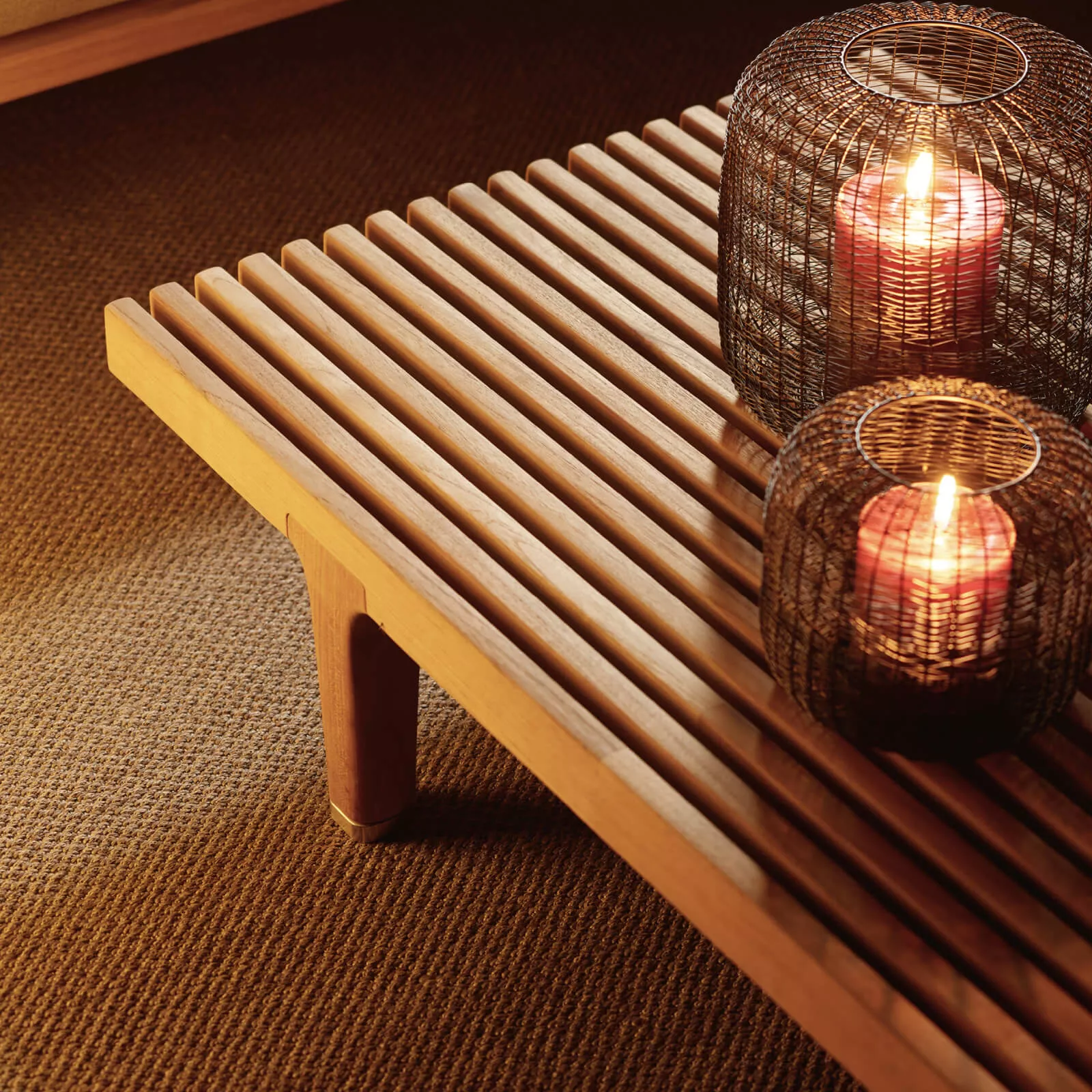 Dedon Sealine Loungetisch aus Holz mit zwei dekorativen Kerzenhaltern auf einem Teppich in einer gemütlichen Wohnatmosphäre