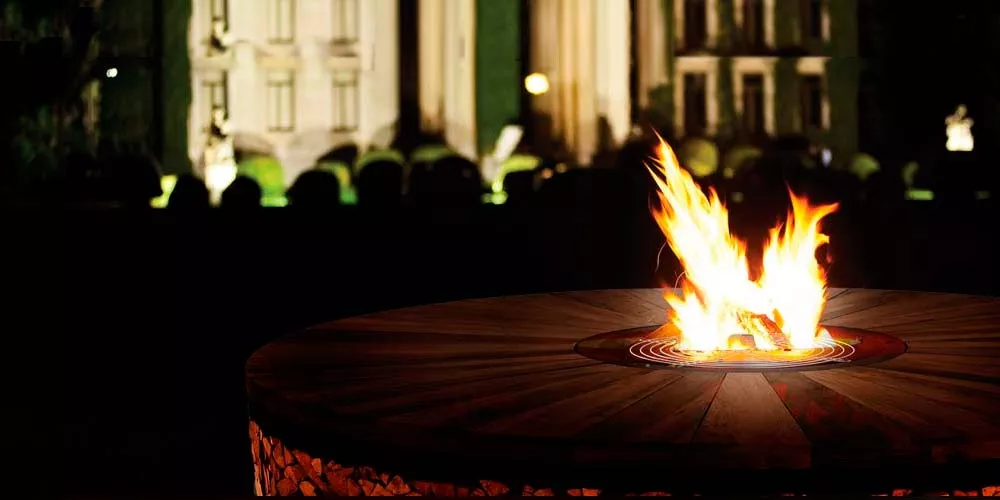 Ak-47 Feuerstellen Artu im Freien mit brennendem Feuer vor einem beleuchteten historischen Gebäude bei Nacht