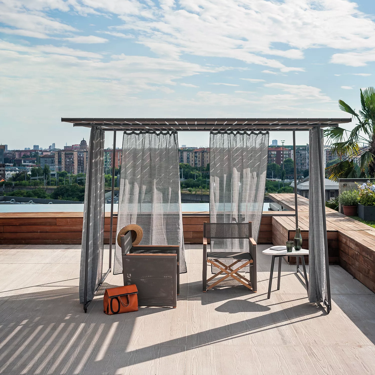 Roda Ombrina Pavillon in Grau auf einer modernen Dachterrasse mit Blick auf die Stadt, umgeben von stilvollen Gartenmöbeln.
