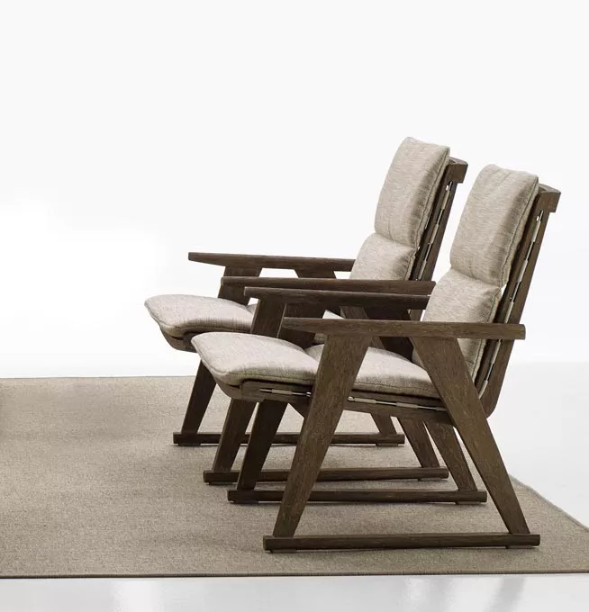 Zwei B&B Italia Gio Loungesessel in hellem Stoff auf einem beigen Teppich in einem minimalistischen Raum ohne Hintergrund.