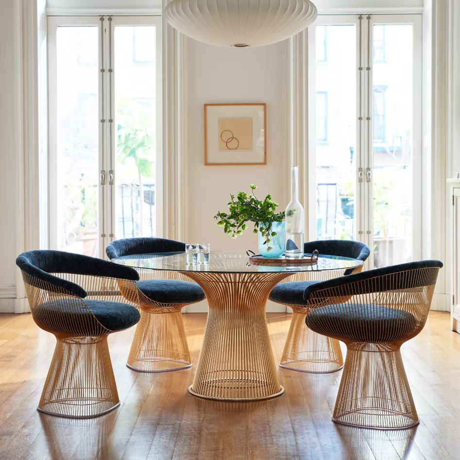 Platner Side Chair von Knoll in Blau und Gold, um einen runden Glastisch in einem hellen Raum mit Holzboden und großen Fenstern arrangiert.