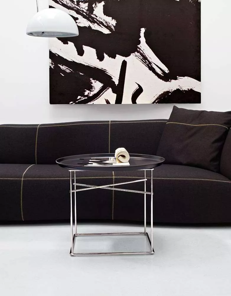 B&B Italia Fat-Fat Beistelltisch in einem modernen Wohnzimmer mit schwarzem Sofa und abstraktem Kunstwerk im Hintergrund