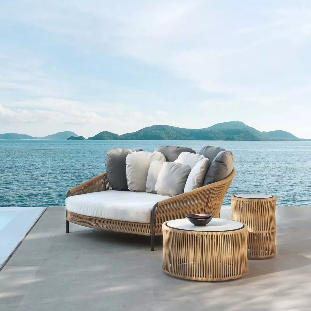 Point Weave Loungetisch mit HPL-Tischplatte in Naturfarbe, 69 cm, auf einer Terrasse mit Meerblick und Inseln im Hintergrund.