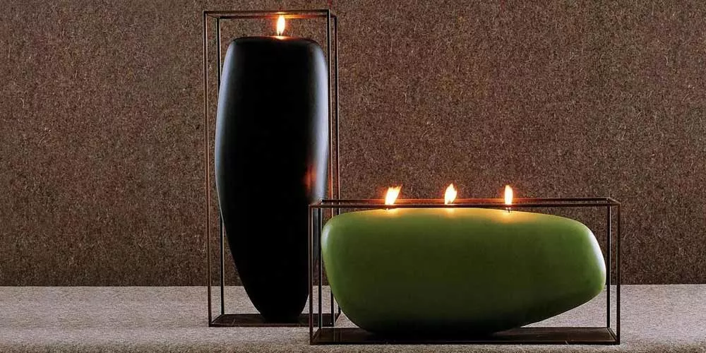 Zwei BeB Italia Overscale Flames Kerzenhalter, einer in Schwarz, der andere in Grün, auf einem strukturierten Hintergrund.