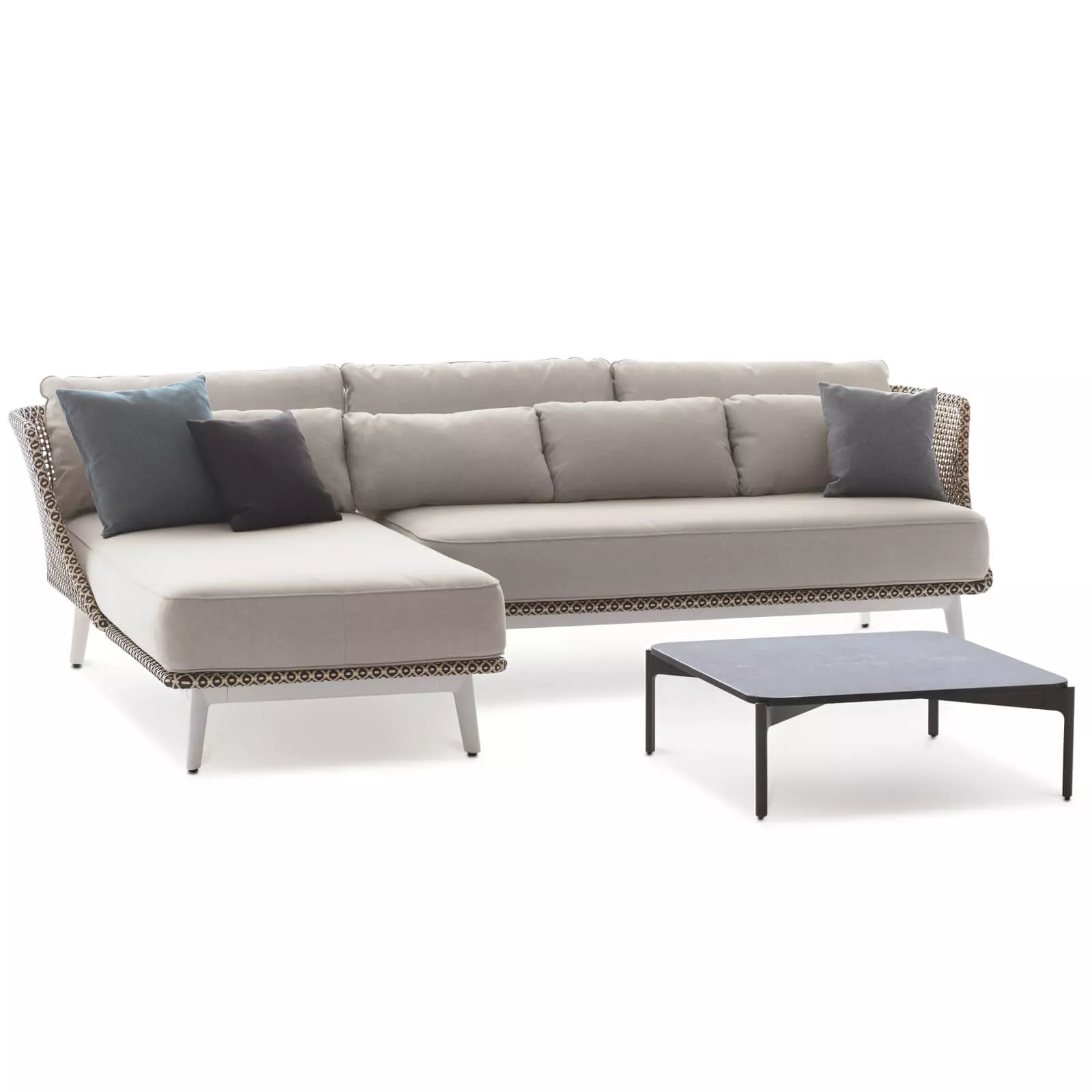 Dedon Mbarq Lounge in beige mit grauen und blauen Kissen und einem schwarzen Couchtisch ohne Hintergrund.