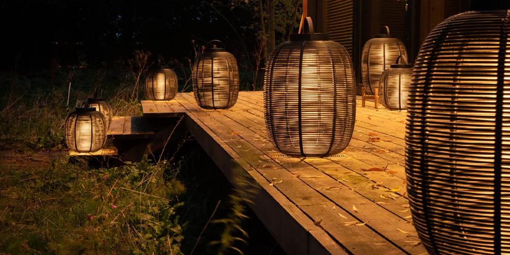 Vincent Sheppard Tika Laternen in Schwarz auf einer Holzterrasse bei Nacht, stimmungsvolle Beleuchtung im Freien.