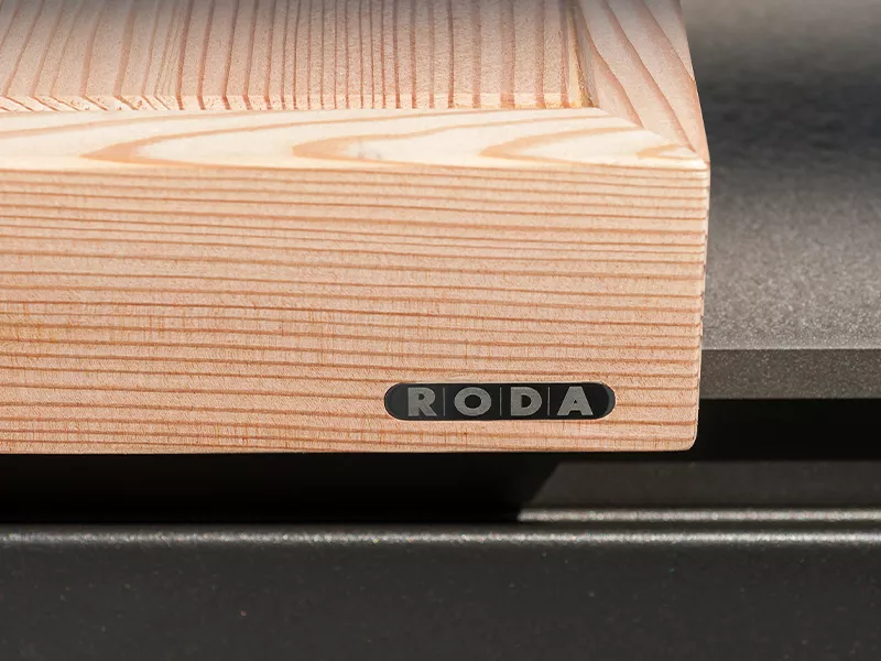 Roda Norma Outdoor-Küche in hellem Holz und dunklem Stein, Detailansicht der Materialien bei Tageslicht.