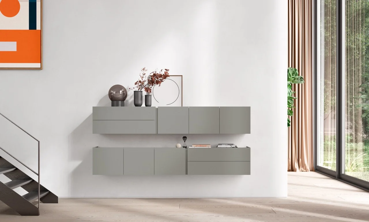 Interlübke Regal in hellem Grau an einer weißen Wand, modernes Wohnzimmer mit Holzfußboden und großem Fenster im Hintergrund.