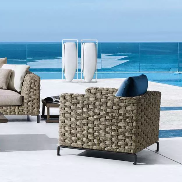 B&B Italia Ray Outdoor Loungesessel 85 cm auf einer Terrasse mit Blick auf das Meer und einem Pool im Hintergrund