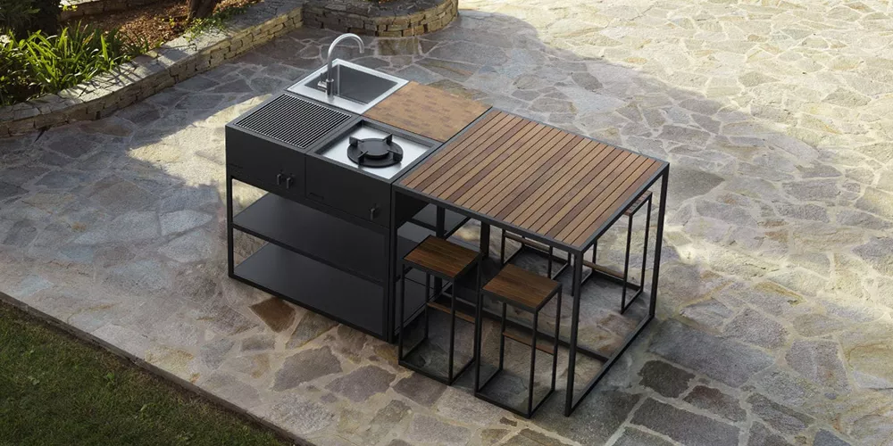 Roshults Open Kitchen Island in Schwarz mit Holzdetails, auf einer Steinplatte im Freien, zeigt eine moderne Outdoor-Küchenlösung.