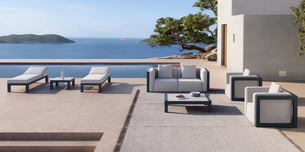 Gandia Blasco Isablanca Kollektion in Weiß auf einer Terrasse mit Meerblick, bestehend aus Sofas, Sesseln und Liegen.