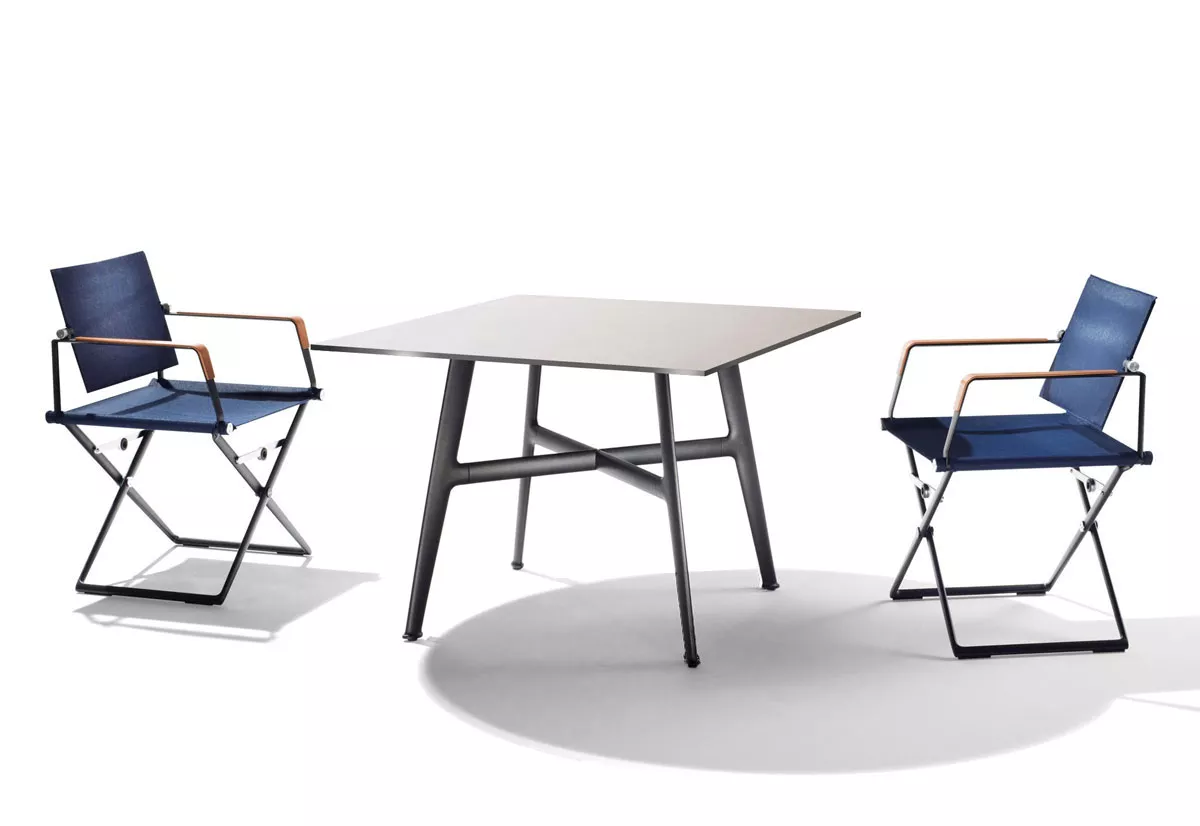 Dedon Seax Esstisch quadratisch 100x100 cm mit zwei blauen Stühlen auf weißem Hintergrund