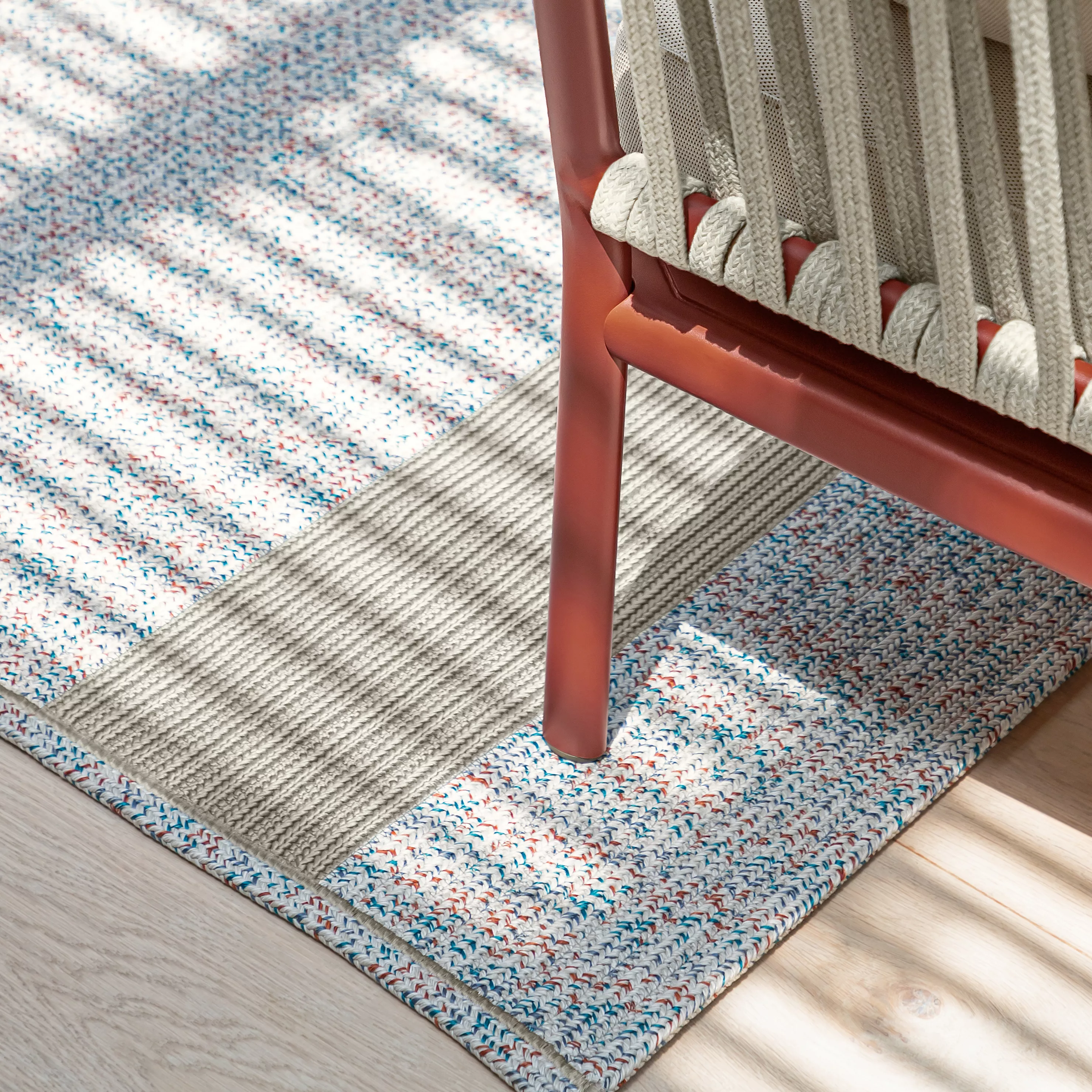 Fast Onda Outdoor-Teppich in Beige mit buntem Muster, Detailansicht auf Holzfußboden bei Tageslicht.