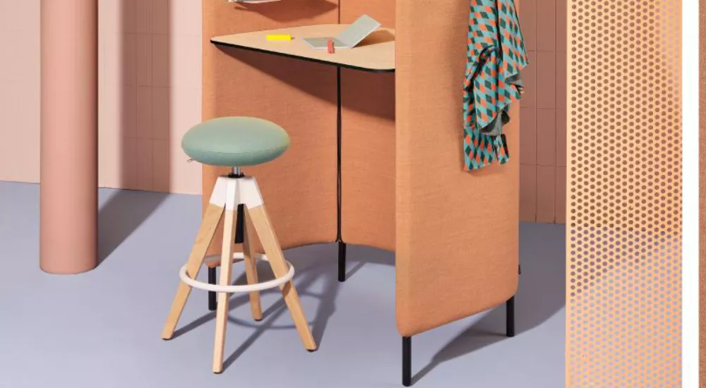 Hocker Pedrali in Mintgrün vor einem modernen, orangefarbenen Raumteiler mit Schreibtisch, auf hellblauem Boden, in einem stilvollen Ambiente.