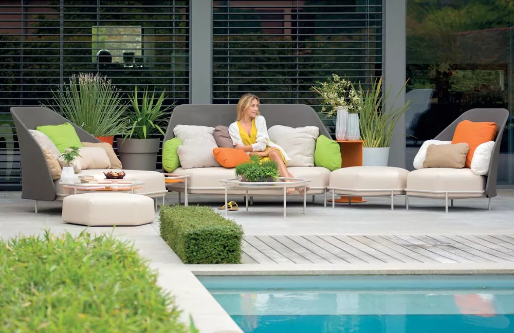 EGO Paris Hive Loungegruppe in Beige und Orange, Outdoor-Mood-Bild am Pool mit Pflanzen im Hintergrund.
