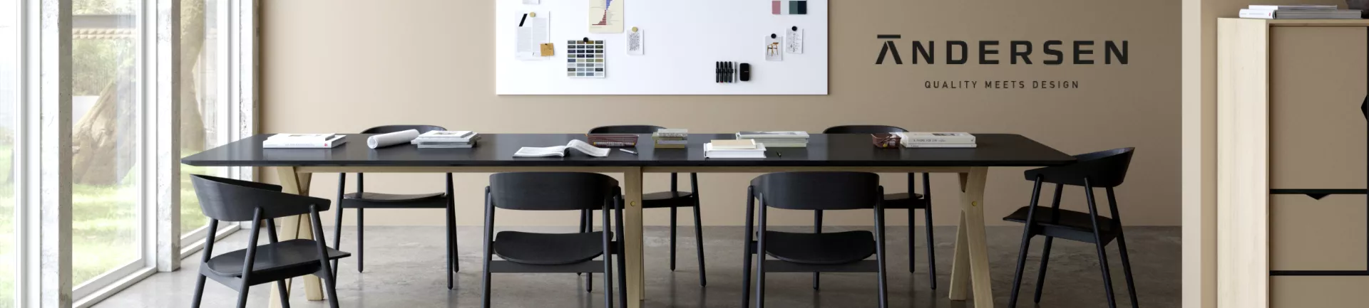 Ein moderner Besprechungsraum mit einem langen, schwarzen ANDERSEN-Tisch und passenden Stühlen vor einer beigen Wand mit Design-Elementen.