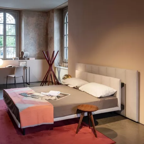 Zanotta Gala Bett in Beige mit Lattenrost, in einem stilvollen Raum mit rustikaler Wand und modernem Dekor, aus seitlicher Perspektive.