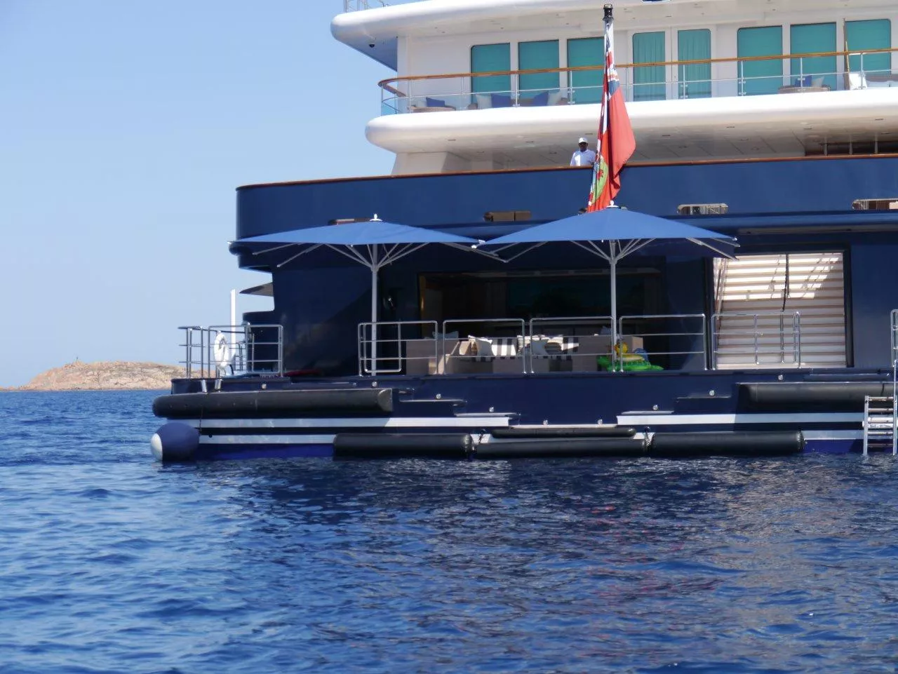 Auf einer Yacht im Meer sind Dedon Lounge Outdoor-Gartenmöbel unter großen blauen Sonnenschirmen zu sehen.