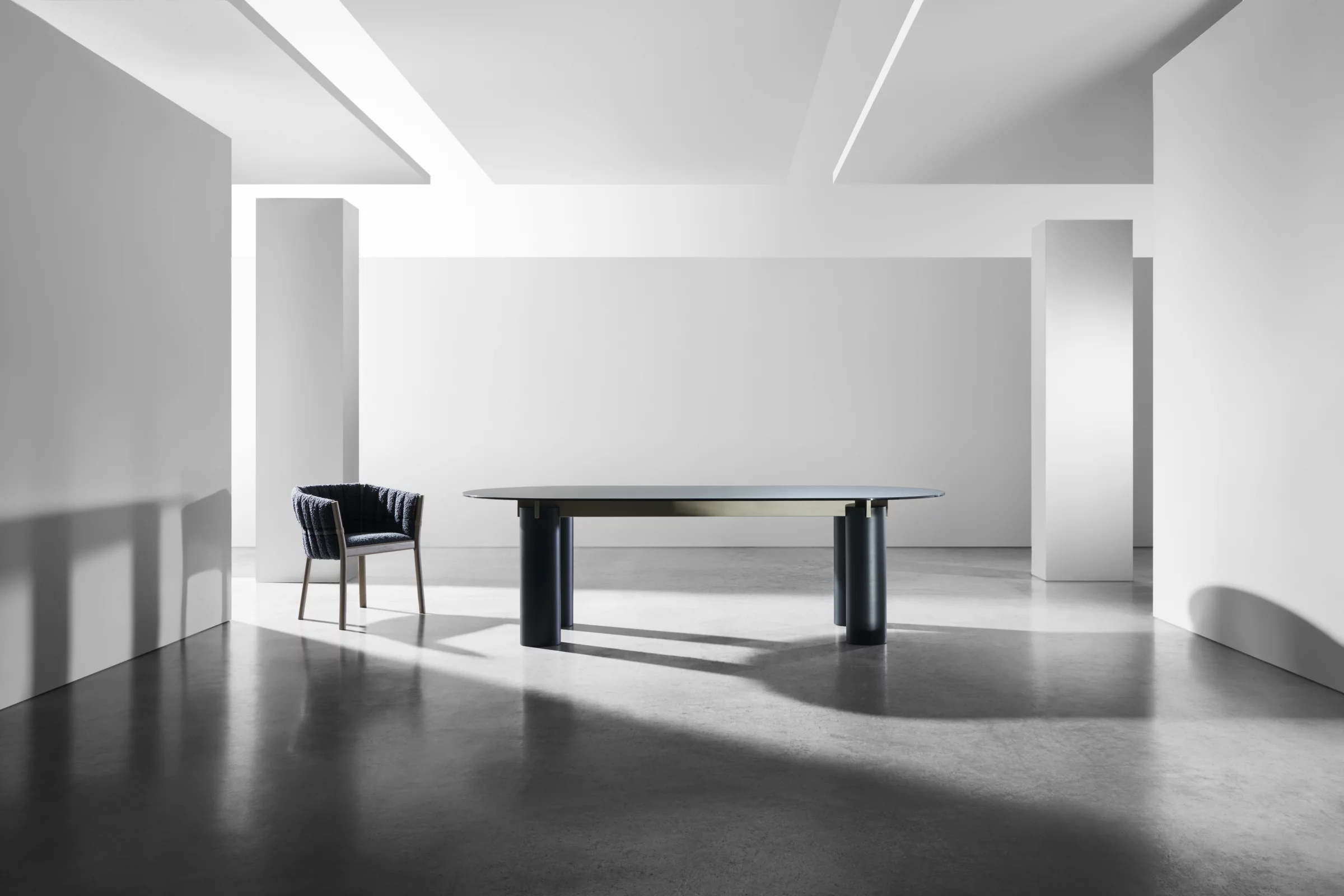 Gervasoni Tisch und Stuhl in modernem minimalistischem Raum mit Betonboden und weißen Wänden