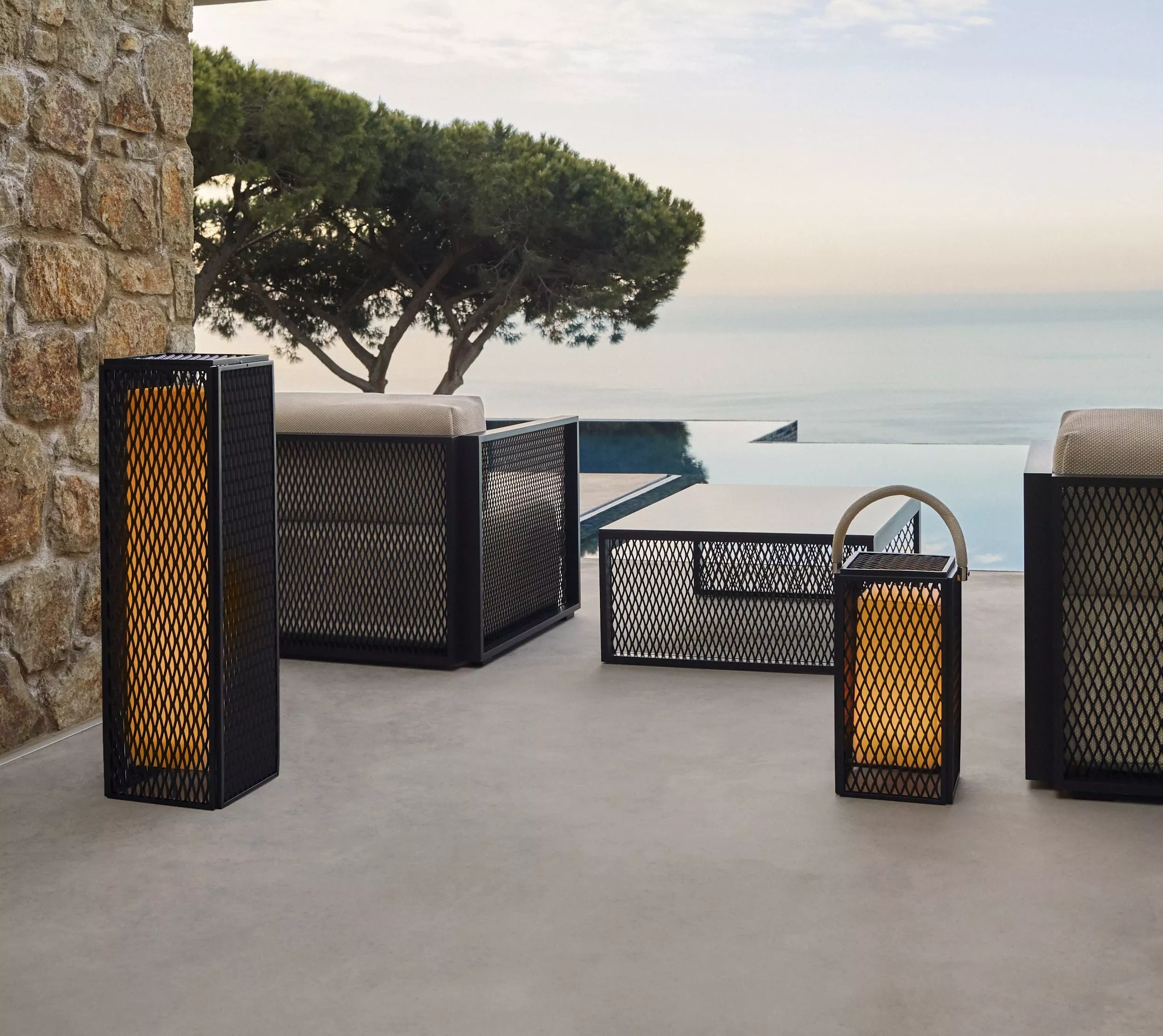 Die Vondom The Factory Collection von Ramon Esteve in Beige und Schwarz auf einer Terrasse mit Blick auf das Meer.