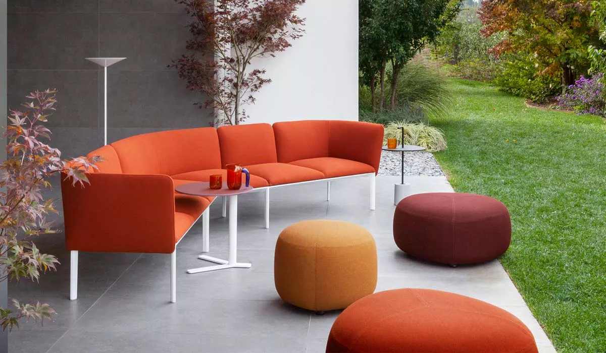 Lapalma ADD Outdoor Loungegruppe in Rot und Orange auf einer Terrasse mit Gartenblick, umgeben von herbstlichen Pflanzen.