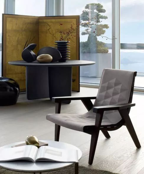 B&B Italia Tobi Ishi Tisch und moderner Sessel in einem stilvollen Wohnzimmer mit großen Fenstern und Blick auf einen See